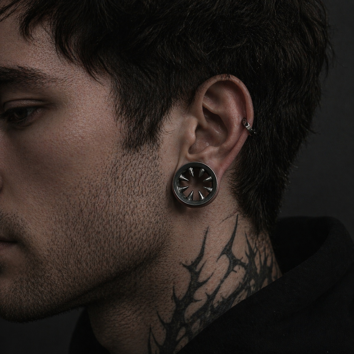 Fanged ear tunnel worn as body jewelry by a man, shown in a close-up side view that reveals the scale and presence of the sculptural form on the ear.